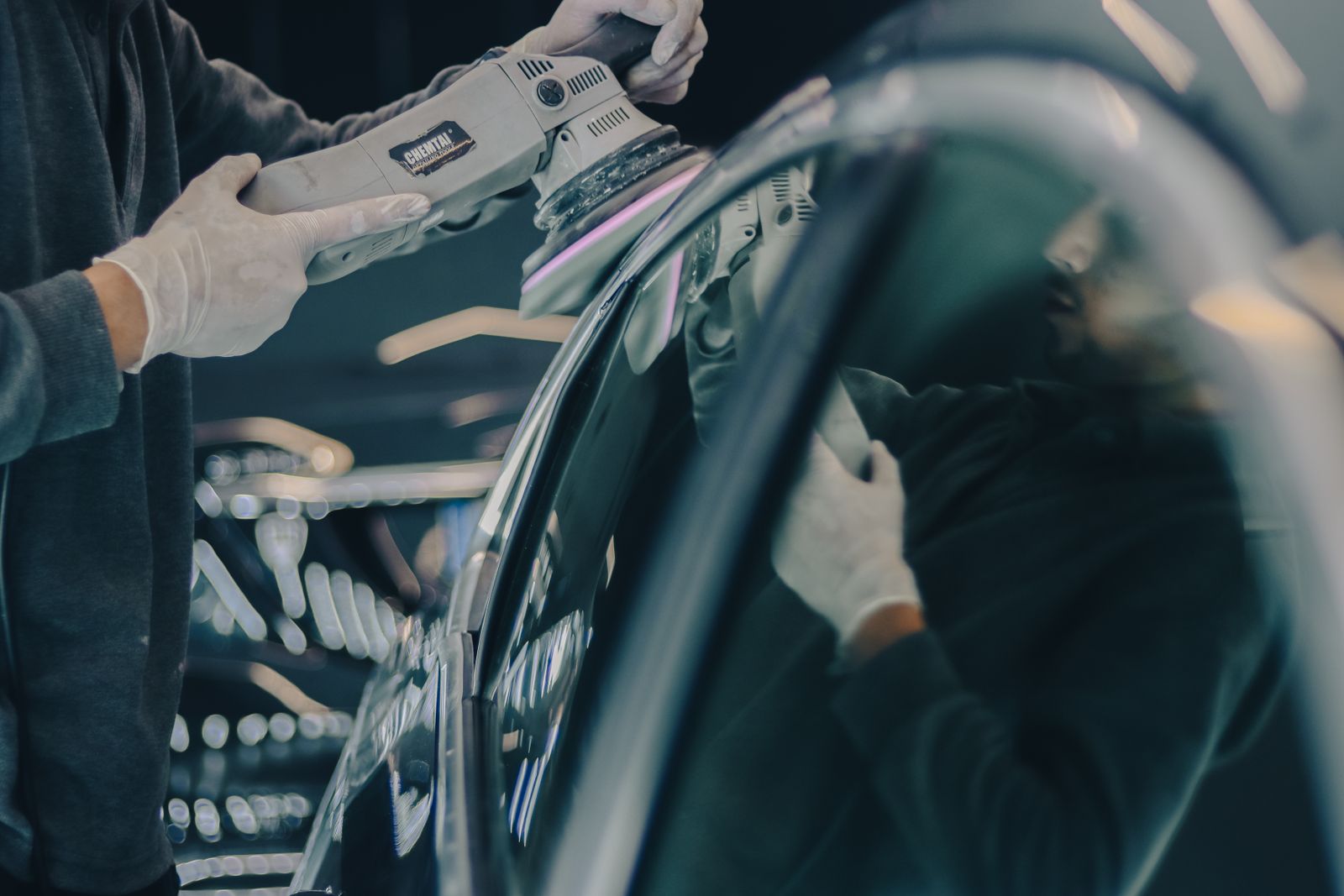 A car photographed on the shop floor under the light bar