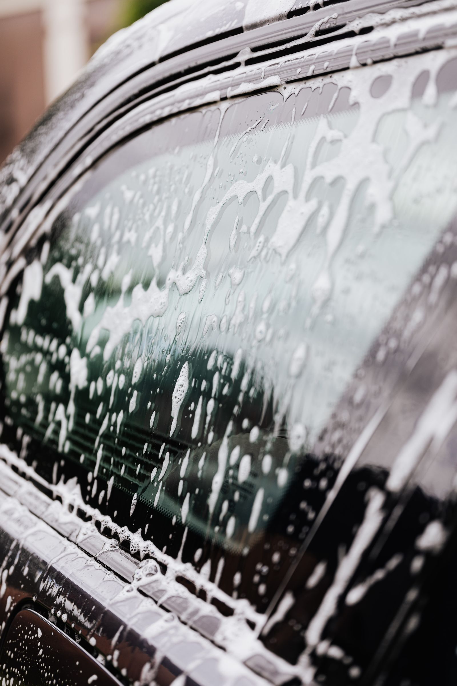 A detailer drying a car panel with a plush towel